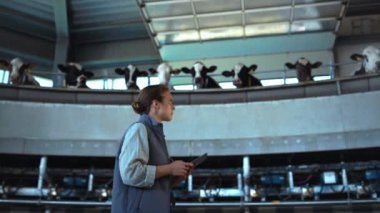 Çiftlik hayvanları işçisi süt sağma atlıkarıncasını gezdiriyor. Ahır müfettişi teftiş salonu