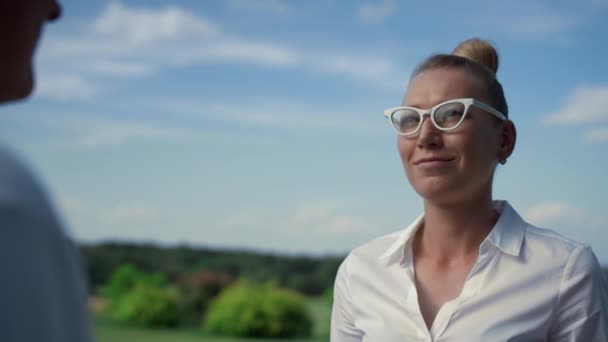 Hermosa mujer sonriendo al aire libre en el campo de golf. Felices golfistas disfrutan hablar. — Vídeos de Stock