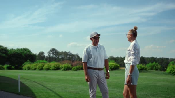 Dois golfistas a falar de desporto no campo. Jogadores de golfe bate-papo na grama fairway. — Vídeo de Stock