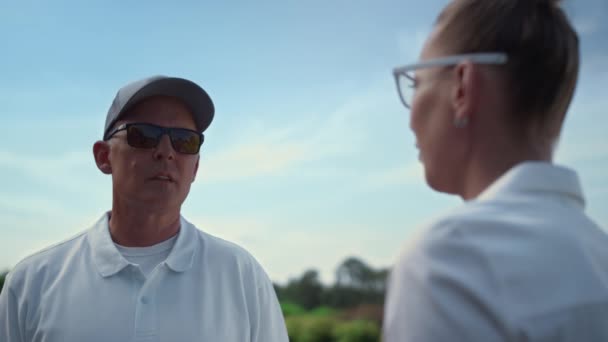 Dois jogadores de golfe a falar no clube de campo. Casal golfistas discutir jogo no fairway — Vídeo de Stock