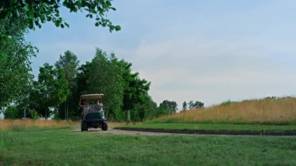 Golf cart che guida fairway fuori. Giocatori di golf esplorare corso nella giornata di sole — Video Stock