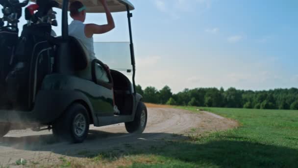 Golf casal carrinho de condução no fairway. Jogadores equipe passeio carro buggy no dia de verão. — Vídeo de Stock