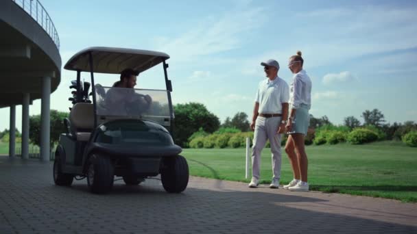 Golf players team meeting at fairway course. Professionals talk sport in cart. — стоковое видео