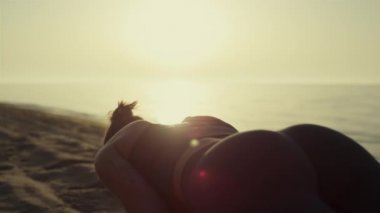 Seksi kız kumlu sahilde spor yapıyor. Yaklaş. Gün batımında yoga eğitimi alan kadın..