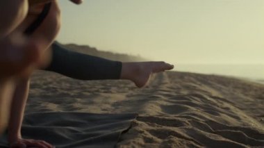 Ellerinin üzerinde duran Yogi kızı vinç pozisyonu alıştırması yapıyor. Bakasana 'yı çalıştıran kadın.