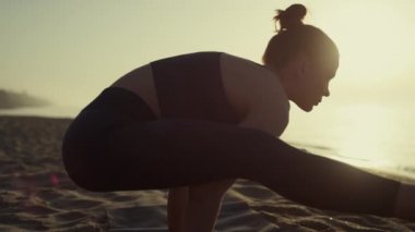 Atletik kadın kollarını açmış yan yana bacaklarını açıyor yoga egzersizleri yapıyor.. 
