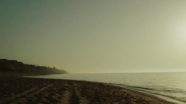 Güneşin doğuşunda kumlu güzel bir sahil. Sakin okyanusun yanında doğa manzaralı bir sabah..