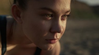 Çekici bir kadın yüzü, kendine güvenen bir bakışla açık havaya bakıyor..