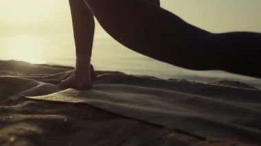Plajda uzanan çıplak kadın bacakları. Kız ayakları yoga pozu verir.