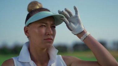 Sportif golfçü yeşil sahada duruyor. Ciddi kadın, dışarı bak..