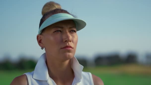 Serious golfer face look away at green field. Focused woman stand on golf course — Vídeos de Stock