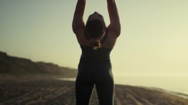 Çekici kız kollarını geri çekip günbatımında briç pozisyonuna hazırlanıyor..