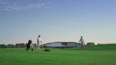 Profesyonel golf grubu sahada spor yapıyor. İş çifti günbatımının tadını çıkarın.