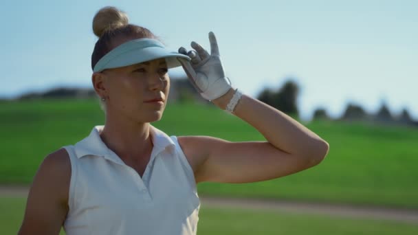 Atractiva dama jugando al golf en el campo verde. Mujer mirando alrededor del campo de golf — Vídeo de stock