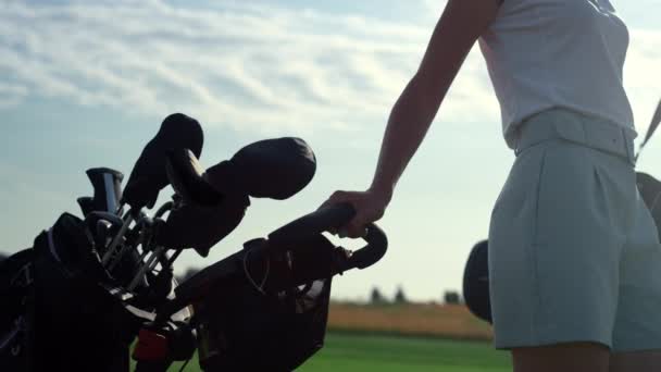 Golf persoon die clubs tas trolley in country club. Vrouw lopen golfbaan. — Stockvideo