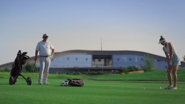 Business couple play golf on course. Two golfers practicing in country club. — Video