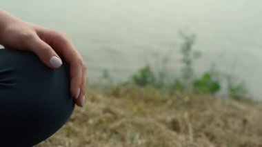 Plajda Lotus pozu veren kimliği belirsiz bir kadın. Genç kız meditasyon yapıyor.