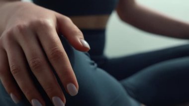 Sağlıklı kadın ellerini dizlerinin üzerine çöküp deniz kıyısında meditasyon yapıyor. Yoga yapan kız..