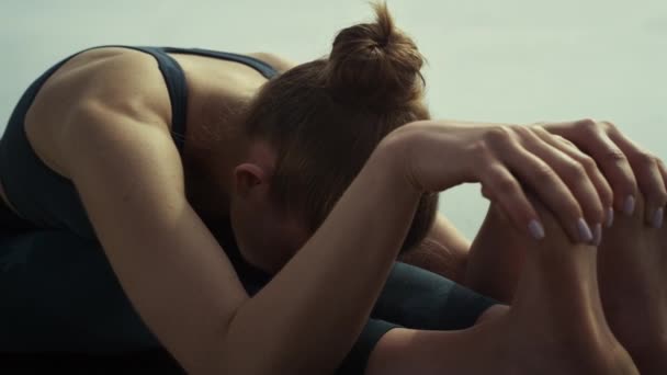 Atractiva chica sentada yoga pose en la playa de cerca. Mujer estirándose al aire libre. — Vídeos de Stock