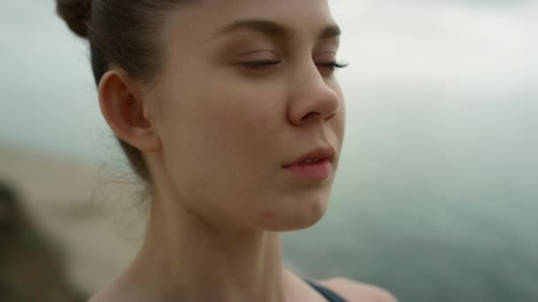 Yoga woman breathing calmly meditating on seaside close up. Girl closing eyes. — ストック動画
