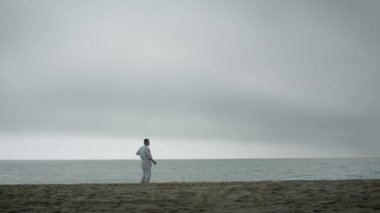 Kumsalda dövüş sanatları eğitimi alan bir savaşçı. Karateci adam dövüş tekniği uyguluyor.