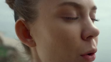 Face woman making breathing exercise on beach closeup. Girl doing yoga on nature