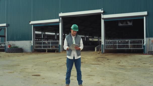 Agriculture worker writing clipboard at cowshed. Smiling supervisor posing alone — Vídeo de Stock