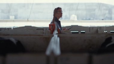 Çiftçi sığırları kırsalda gezdiriyor. Tablet bilgisayar tutan odaklı kadın