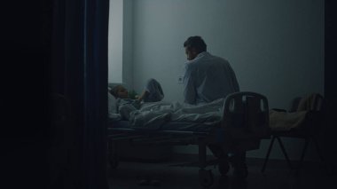 Doktor hasta çocuğu koğuşta ziyaret ediyor. Hastanede sağlık kontrolü.