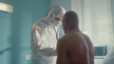 Hastanedeki steteskoplu Afrikalı hastayı muayene eden bilinmeyen bir doktor..