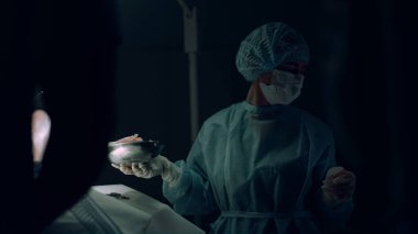 Hastane acil servisinde doktorlara yardım eden cerrahi aletler veren hemşire..