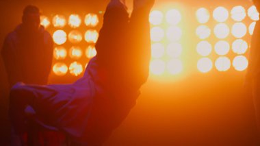 Siluet break dans grubu gece kulübünde dans ediyor. B-boys serbest stil yapıyor..