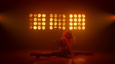 Seksi kadın vücudu duygusal bir şekilde dans pistinde yatıyor. Ateşli esnek kız dans ediyor.