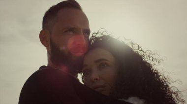 Genç çift güneş gökyüzünde birbirine sarılıyor. Sakin sevgili kız arkadaş, dışarıda rahatla.