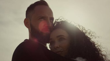 Evli çift güneş ışığında birlikte rahatlıyor. Latin aşıklar günbatımının tadını çıkarıyor.