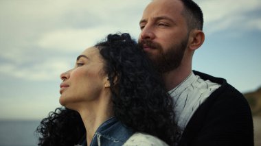 Deniz manzarasında birbirine sarılan iki insan. Romantik çift plaj manzarasının tadını çıkarıyor..