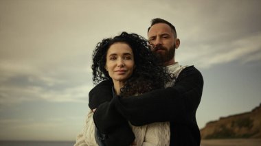 Sahilde kucaklaşan genç bir çift. İki aşık sakin tatilin tadını çıkarır.