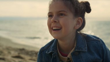 Yaz tatilinde kumsalda oynayan gülümseyen kız. Neşeli çocuk deniz kenarında eğleniyor..