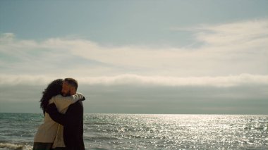 Neşeli çift deniz sahilinde birlikte eğleniyor. Gençler doğayı sever.