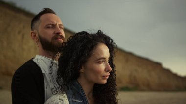 Çift gün batımının tadını çıkarıyor. Deniz kıyısında kucaklaşan romantik eşler.