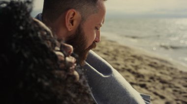 Sahile bakan çok ırklı bir çift. Açık denizde dinlenen düşünceli insanlar..