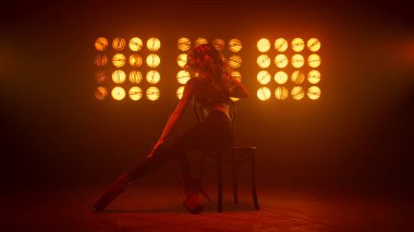 Seksi vücutlu bir kadın sahnede striptiz yapıyor. Seksi sarışın dans ediyor.