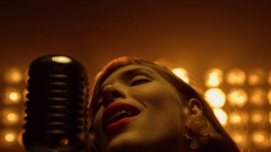 Gece kulübünde güzel bir sarışın şarkı söylüyor. Tutkulu kadın şarkı söylüyor