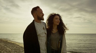 Mutlu aşıklar açık havada deniz batımında yürüyor. İspanyol çift sahilde eğleniyor..