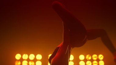 Gece kulübü sahnesinde akrobatik elementler dansı yapan kız dansçı..