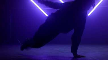 Havalı break dansçı, kulüpte hiphop hareketleri gösteriyor. Siluet dansçısı..
