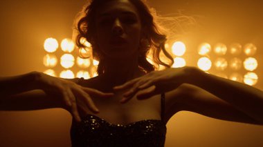 Gece kulübünde dans eden güzel bir kadın. Seksi kız saçlarına dokunuyor..