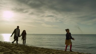 Sahilde yürüyen güzel insanlar. Neşeli aile tatil denizinde iyi eğlenceler.