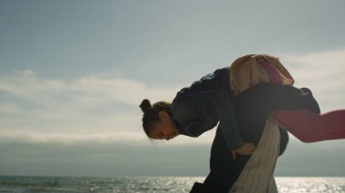 Mutlu baba deniz sahilinde çocuğu taşıyor. Ebeveyn çocuk dışarıda dönüyor..