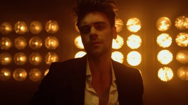 Profesyonel olarak aydınlatılmış lambalarla poz veren çekici bir adam. Portre yakışıklı adam.